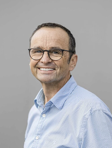 Mann mit blauer Hemd steht.