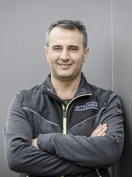 Mann mit verschränkten Armen, sportlich gekleidet.