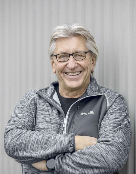 Person mit grauem Pullover und verschränkten Armen